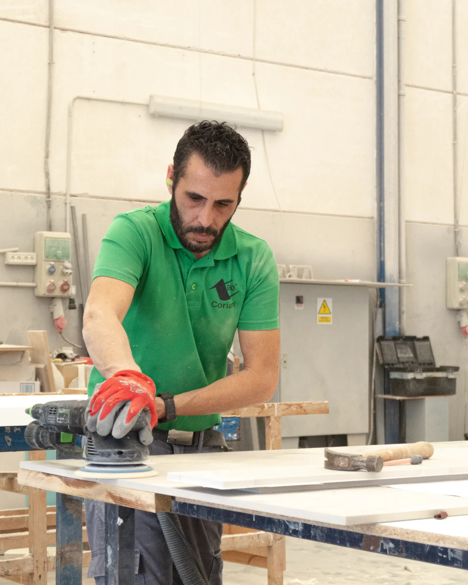 Trabajador lijando una pieza blanca en el taller