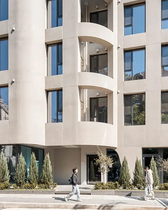 Fachada residencial con balcones curvos revestidos en tono claro