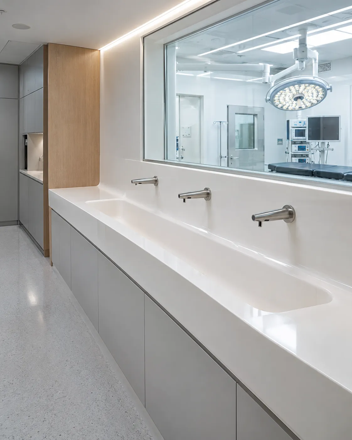 Lavabo quirúrgico continuo de Corian® blanco con grifos de sensor